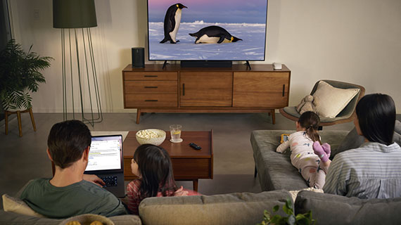 Family sitting around a TV each on their won devices