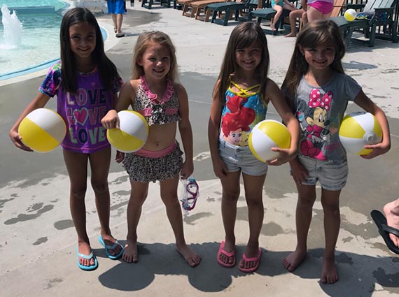 Children posing for a picture with Vyve beach balls at Shawnee Splash!