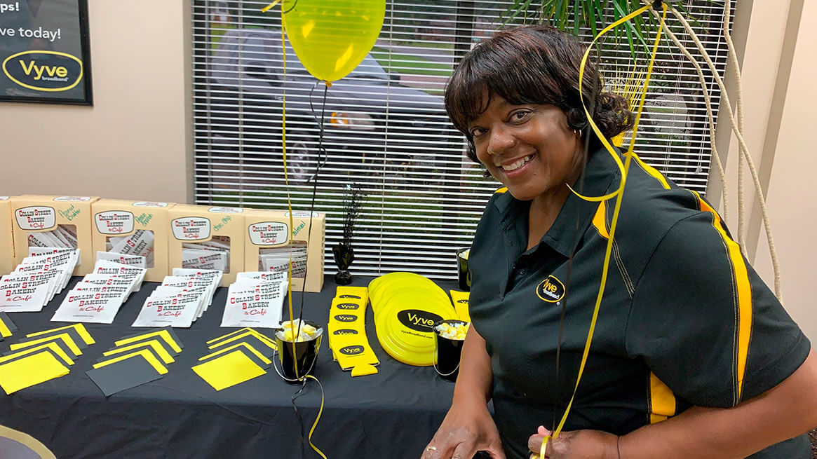 Vyve Sales team member holding a balloon next to a table of cookies